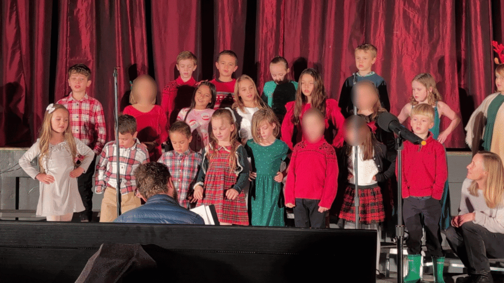 Children performing school choir concert at El Dorado Adventist School in festive attire.