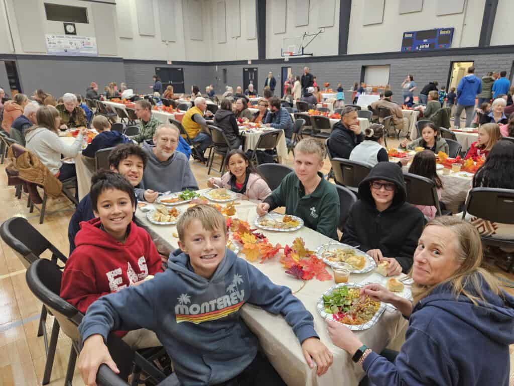 Fall school banquet at El Dorado Adventist School showcasing students and families enjoying a festive meal in a gymnasium.