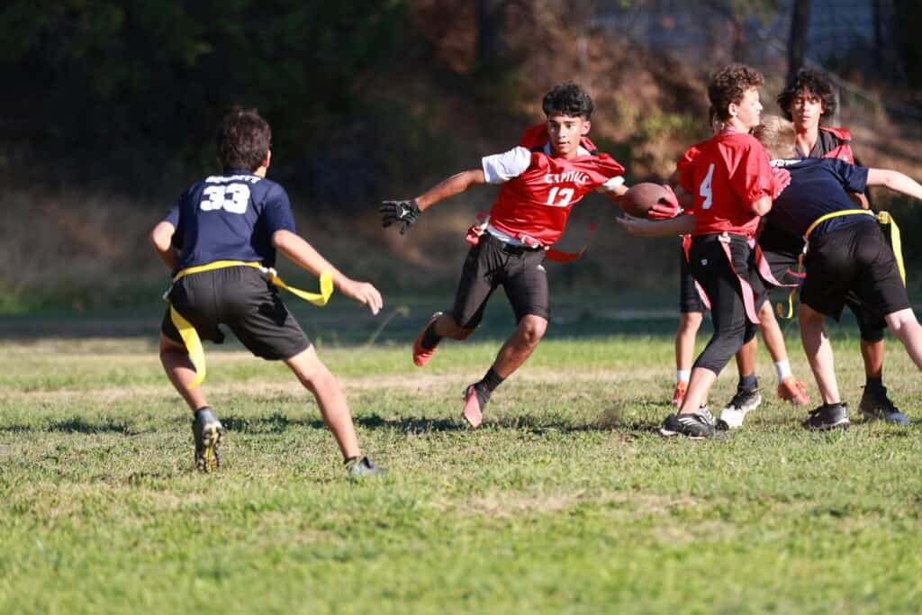 Children playing flag football on school sports field at El Dorado Adventist School.