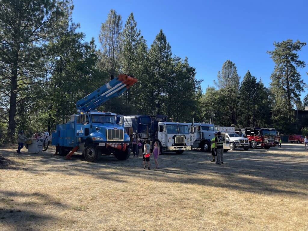 Large fire trucks and emergency vehicles at El Dorado Adventist School outdoor event.