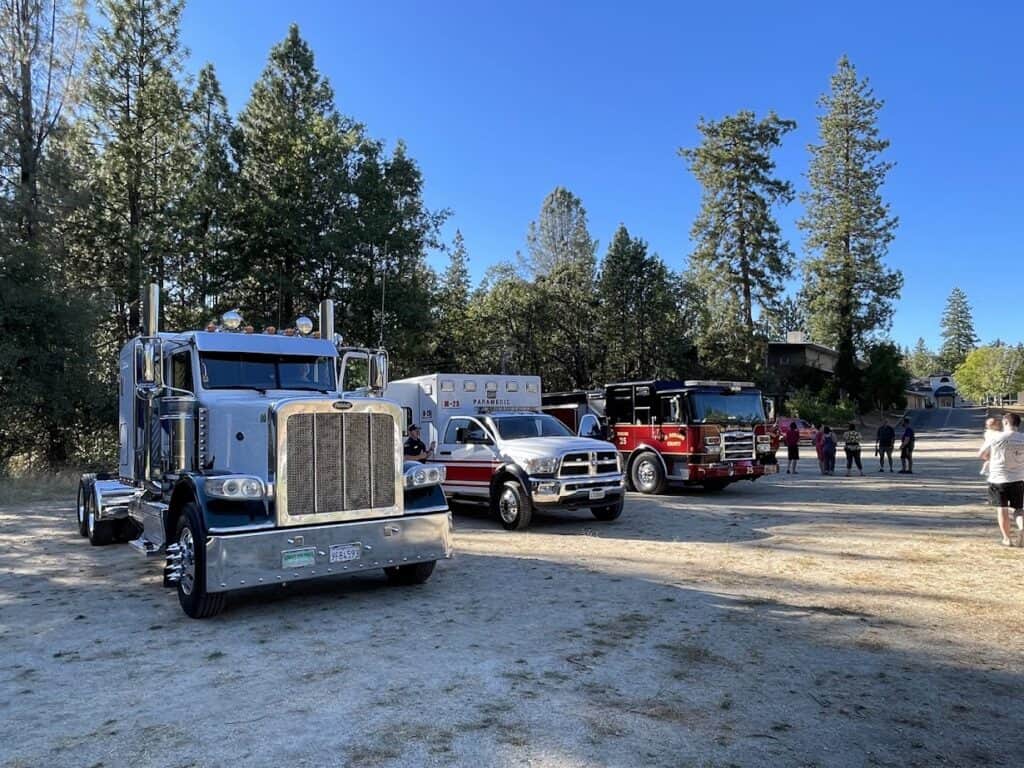 Large firefighting trucks parked outdoors at El Dorado Adventist School campus during a community safety event.