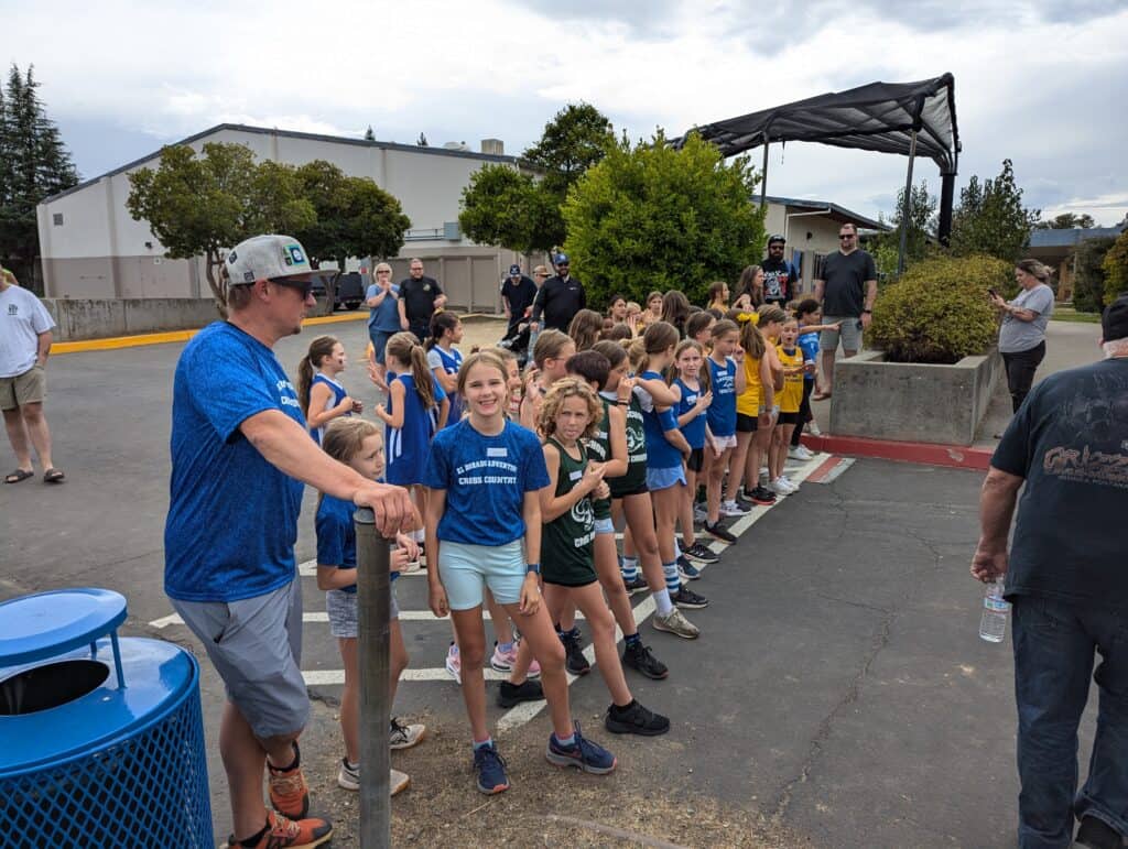 Students gathering outdoors at El Dorado Adventist School for a cross country event, showcasing school community and student athletics.