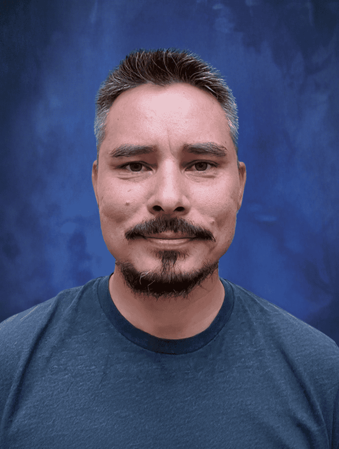 Formal portrait of a smiling male teacher at El Dorado Adventist School, showcasing educational staff.