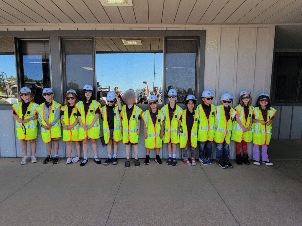 High school students wearing safety vests and hard hats in a school field trip.