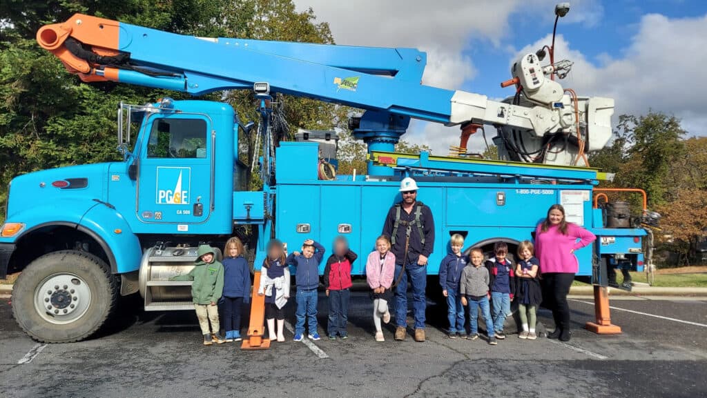 School children visiting utility truck at El Dorado Adventist School for a safety lesson and community outreach.
