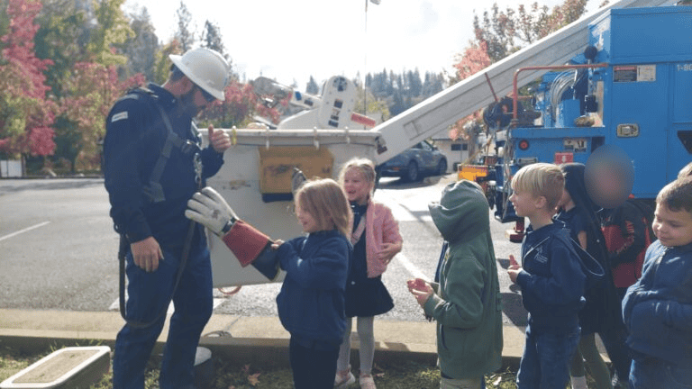 Learning safety with utility workers at El Dorado Adventist School. Children engaged in educational community demonstrations.