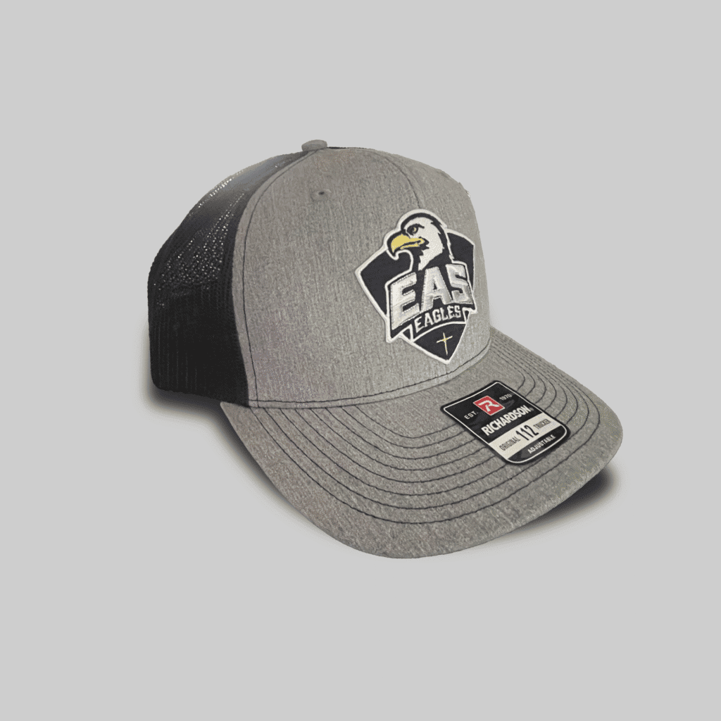 EAS Eagles logo on a gray and black trucker cap, representing El Dorado Adventist School apparel and accessories.