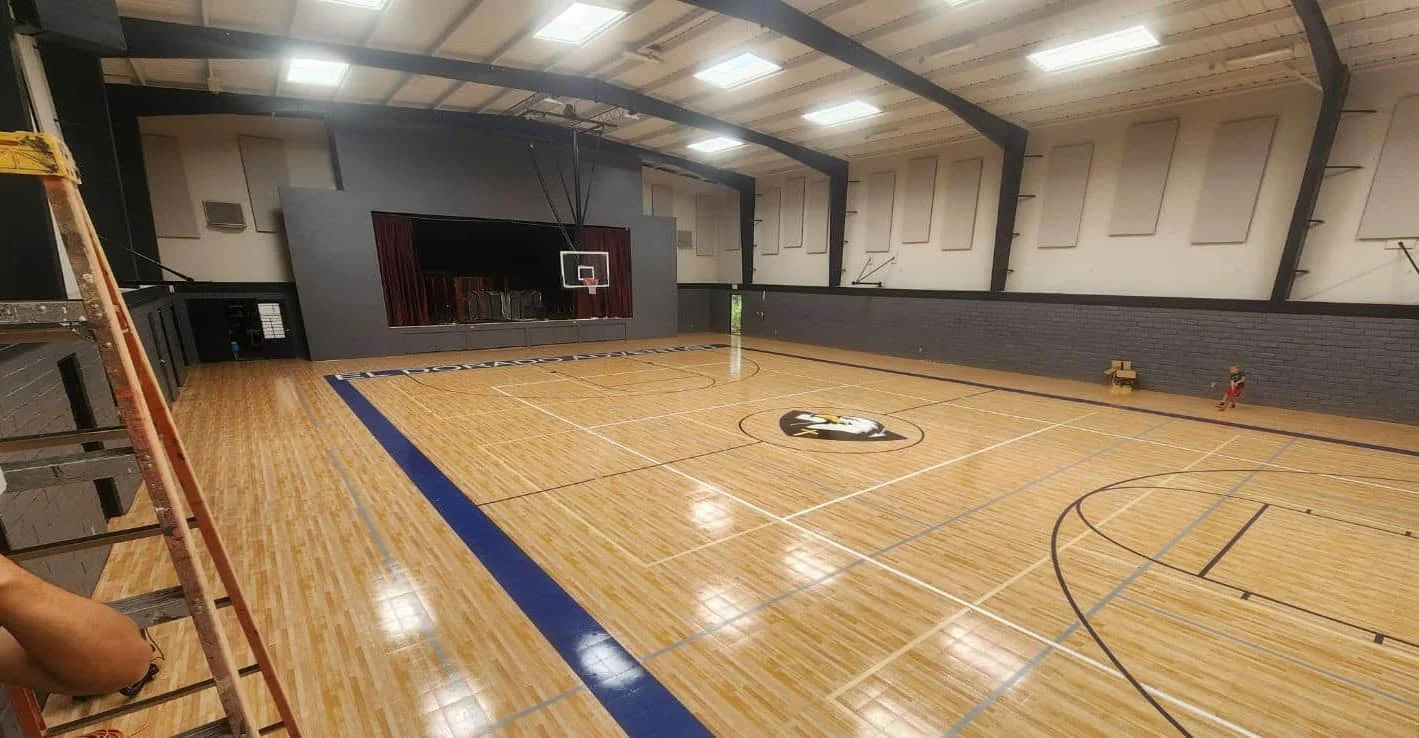Gymnasium with hardwood flooring and basketball court at El Dorado Adventist School.