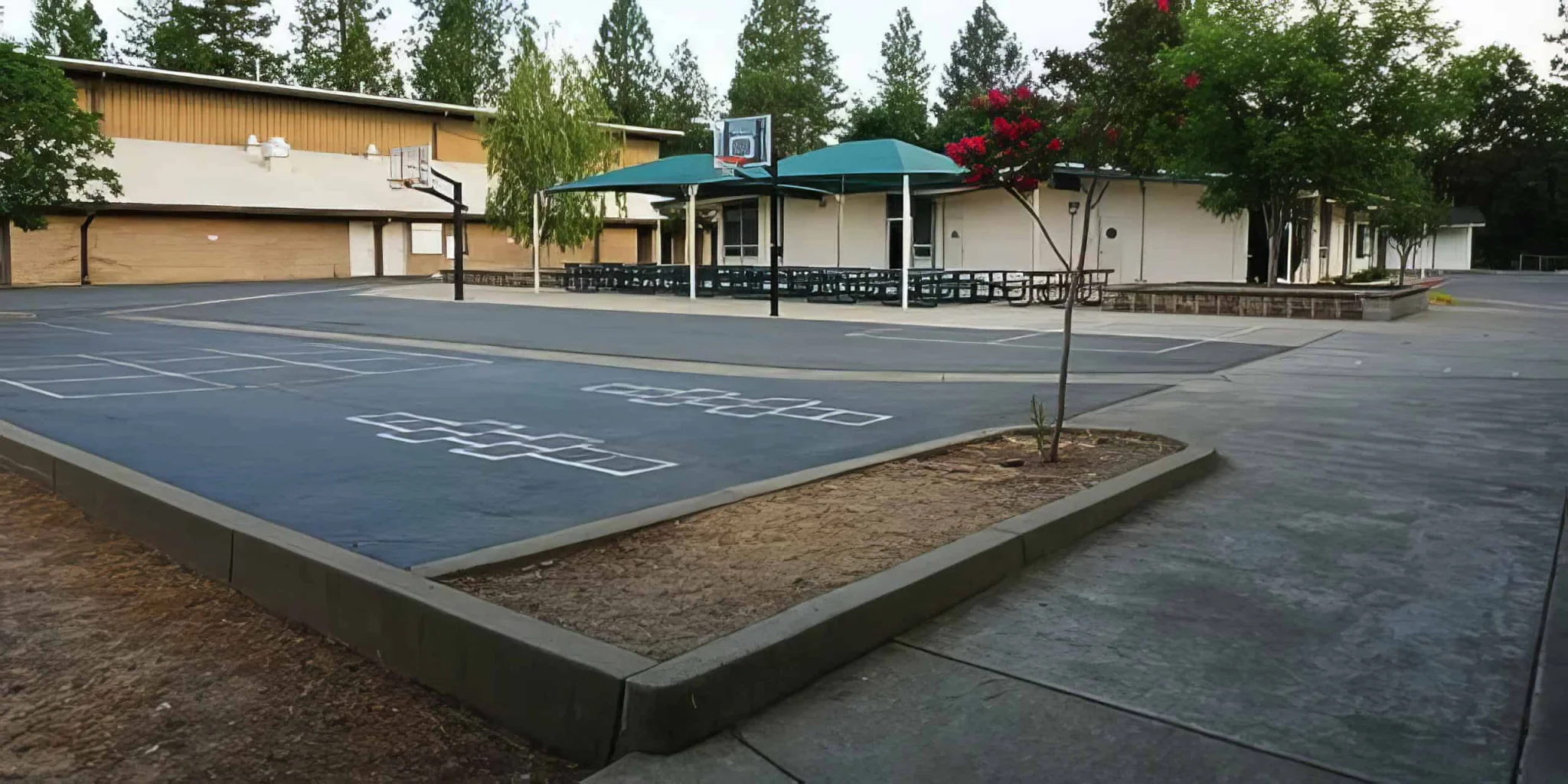 Empty school playground with basketball court at El Dorado Adventist School, outdoor recreational facilities for students.