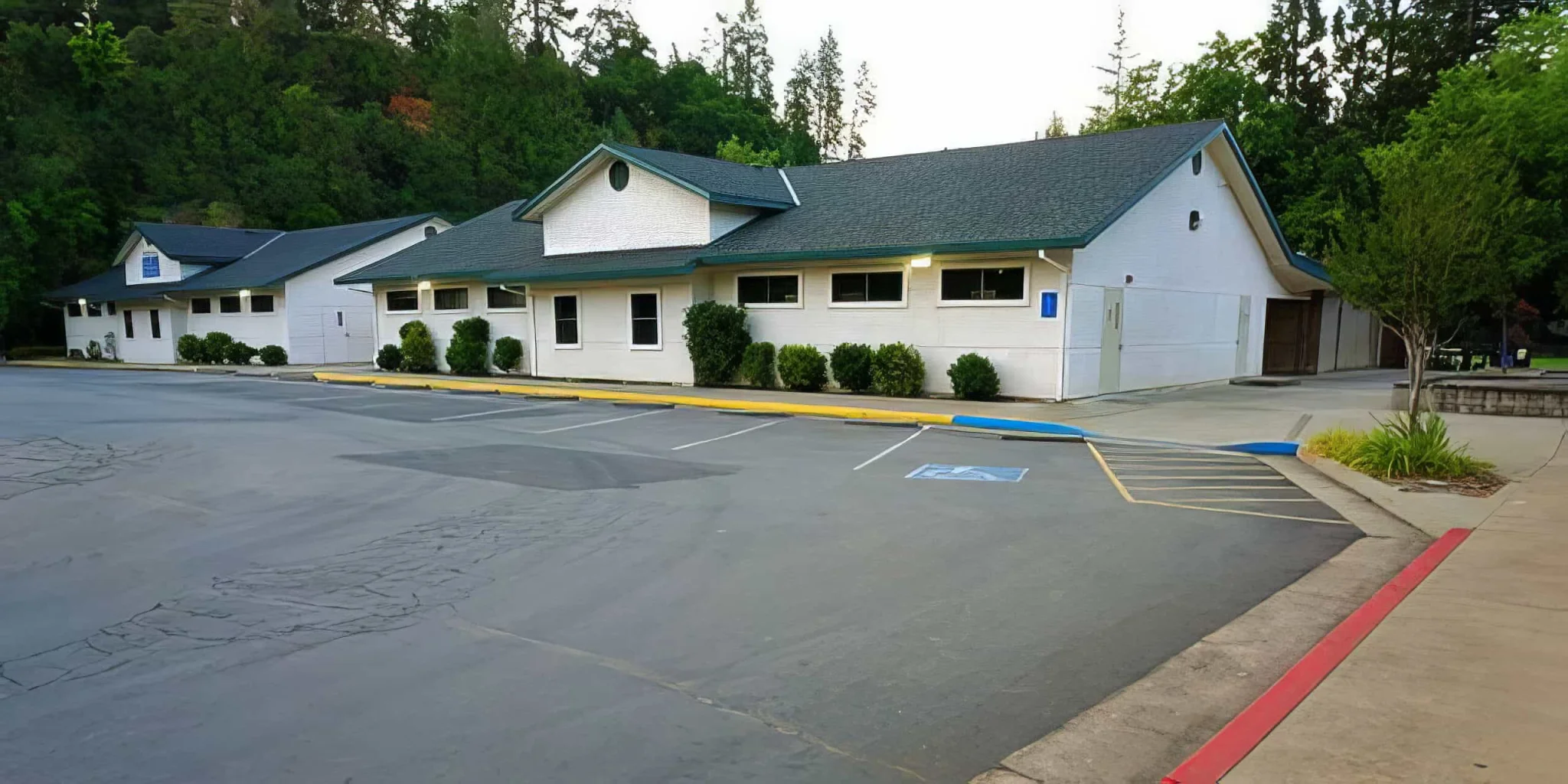 Senior high school building at El Dorado Adventist School with parking lot and surrounding greenery.