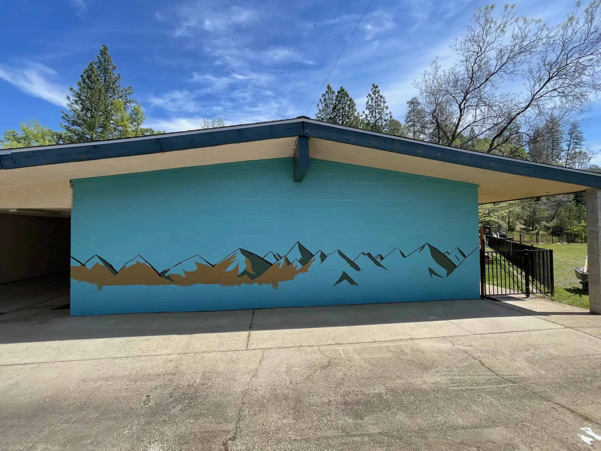 Colorful mountain mural on a light blue building exterior at El Dorado Adventist School.